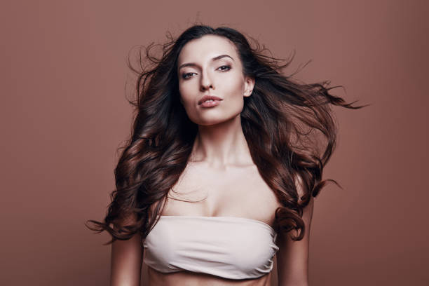 istock Proud to be beautiful. Attractive young woman looking at camera while standing against grey background 1154977147