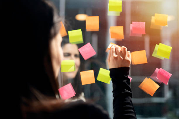 istock Young businesswoman working with stickers note on glass window 1154977985