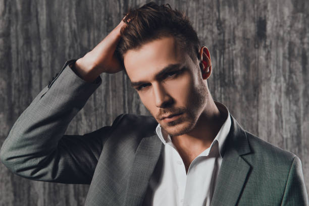 istock Attractive rigid man in business suit on the grey background 1154978128