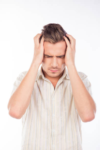 istock Handsome young man touching his head feeling headache 1154978170