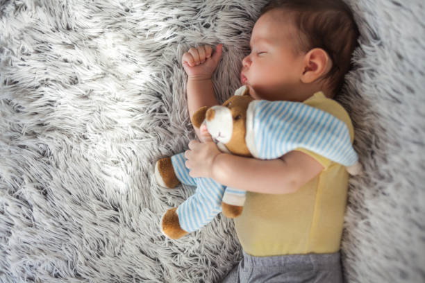 istock Baby boy sleeping with teddy bear 1154978360
