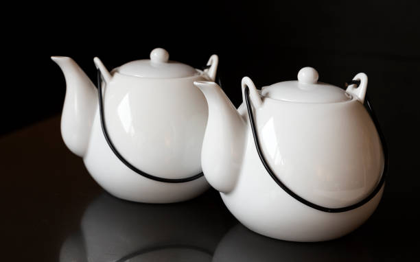 istock White kettles or tea pots on black background 1154982410