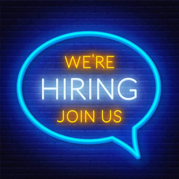 istock Neon sign we are hiring - join us on the brick wall background. Light poster or banner for recruiting. 1154983093