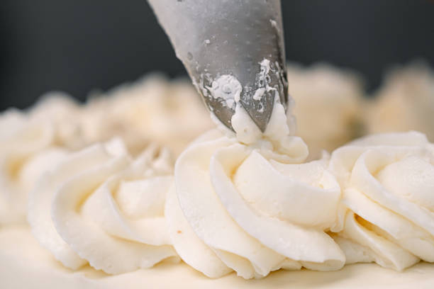istock Decorating a white cake with cream from the pastry bag. Macro shot, closeup. 1154983396