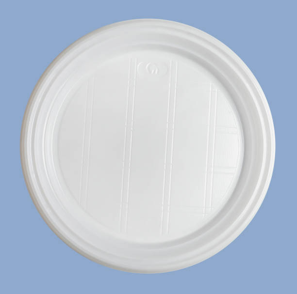 istock White plastic disposable plate isolated on blue background. Close-up. 1154983404