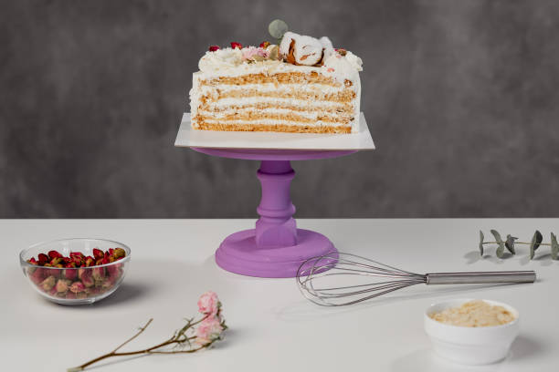 istock Confectioner's table. Cut white puff cake and pastry tools. 1154983649