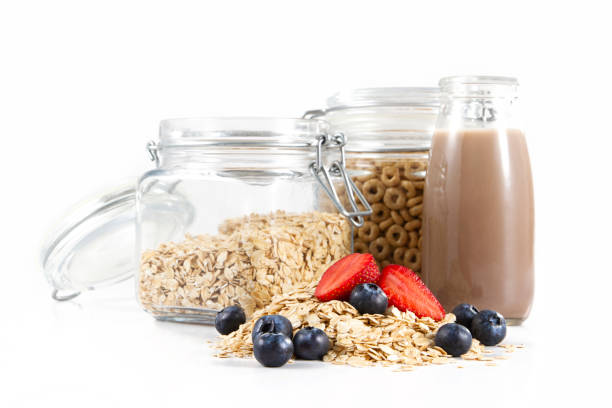 Heap of oats and fresh fruits and breakfast ingredients isolated on white background