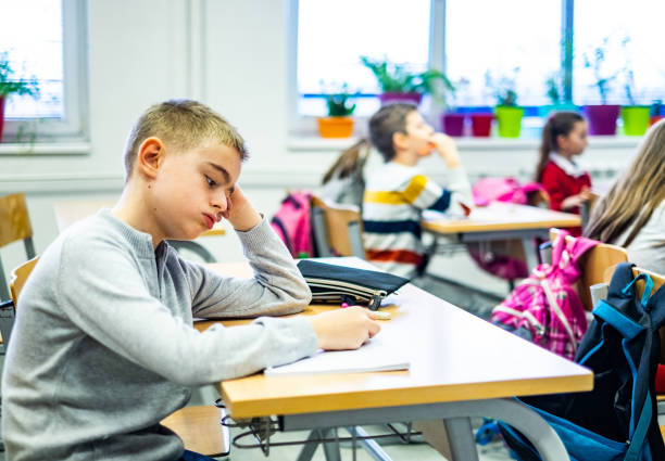 istock The schoolboy is bored in school 1154987142