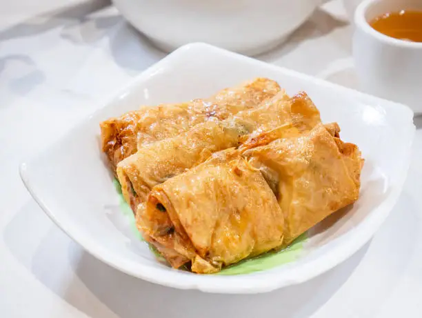 Delicious dim sum, famous cantonese food in asia - Fried bean curd (tofu skin) rolls with shrimp and prawn in hong kong yumcha restaurant, close up