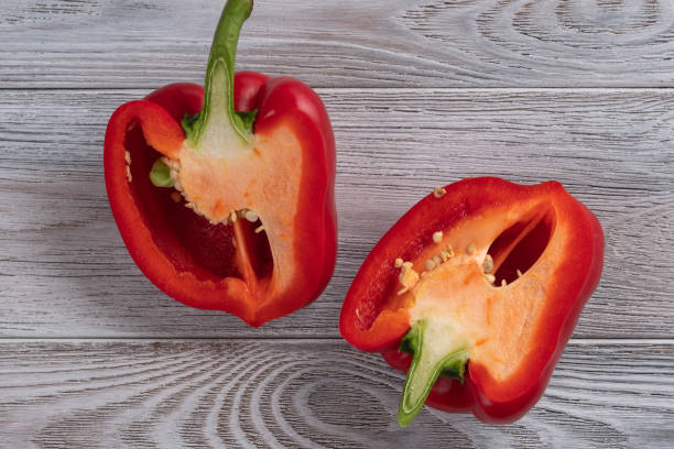 istock Red pepper cut in half close up on a wooden table 1154988496