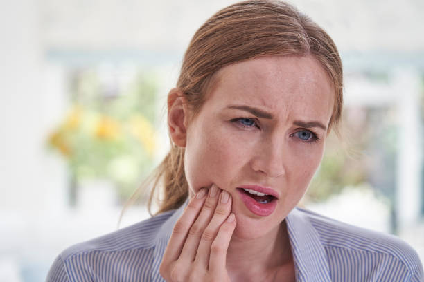Young Woman Suffering With Toothache Touching Jaw Young Woman Suffering With Toothache Touching Jaw jaw pain stock pictures, royalty-free photos & images