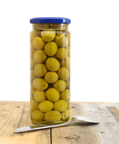 istock green olives in closed container and spoon on wooden board 1154990623