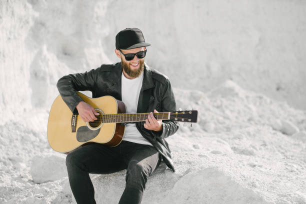 istock Guitar player with beard and black clothes 1154992401