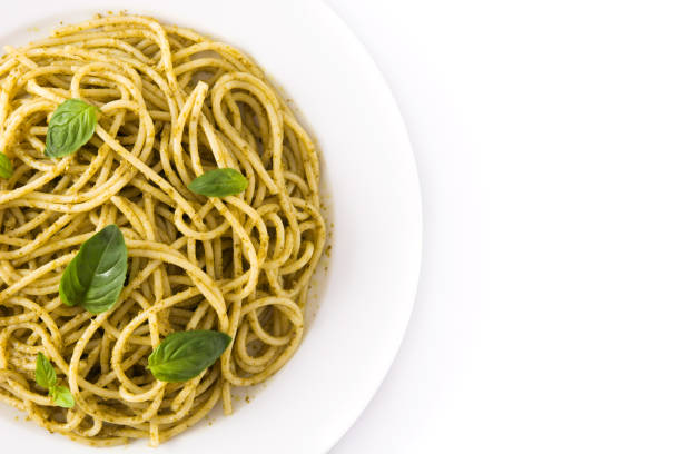 Spaghetti pasta with pesto sauce isolated on white background
