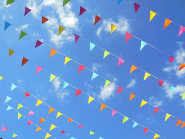 istock multicolored paper bunting flags in blue sky 1154995429