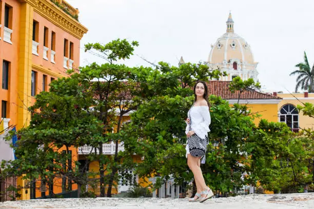 Beautiful woman on white dress walking alone at the walls surrounding the colonial city of Cartagena de Indias