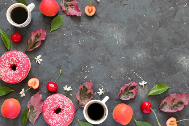 istock Coffee, fruits and pink donut on dark background. 1154996691