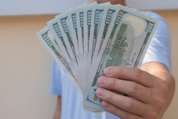 istock Asian man holding one hundred dollar bill. Wealthy and richness concept. 1154996698