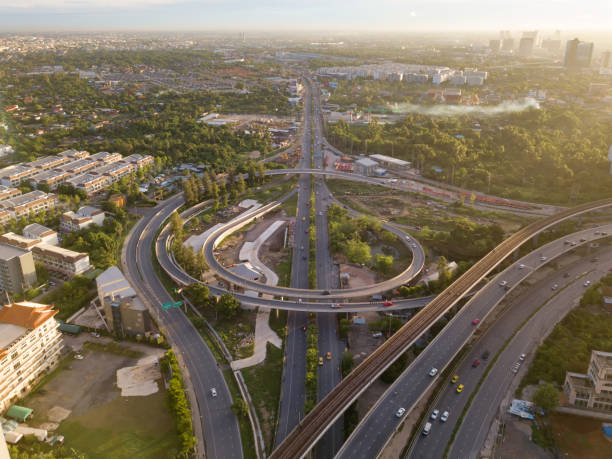 istock Aerial view of highway junctions with roundabout. Bridge roads shape circle in structure of architecture and transportation concept. Top view. Urban city, Bangkok at sunset, Thailand. 1154999695