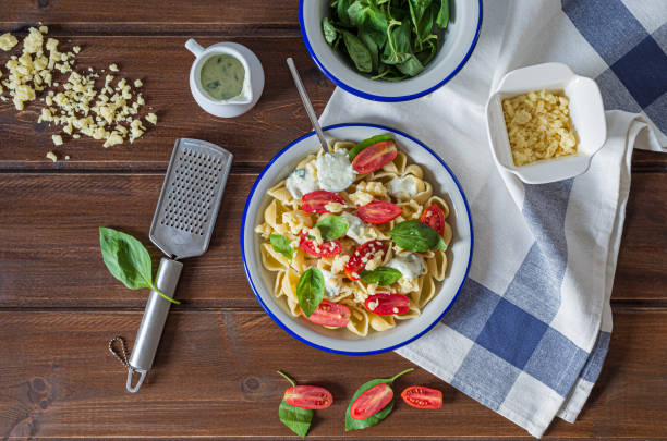 Homemade Italian pasta, sour cream with pesto , cherri tomatoes and basil stock photo