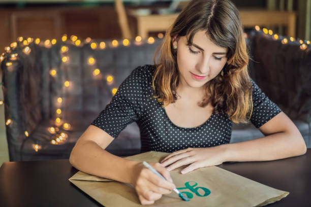 緑に行く。書家の若い女性がホワイトペーパーにフレーズを書きます。inscribing 装飾文字。書道、グラフィックデザイン、レタリング、筆跡、創作コンセプト - women white caucasian image created 19th century ストックフォトと画像