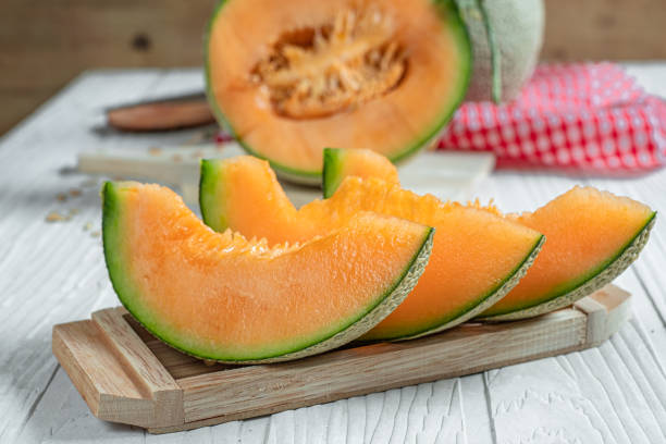 istock Orange melon on wooden cutting board and table 1155012706