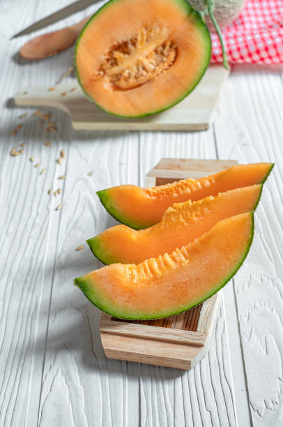 istock Orange melon on wooden cutting board and table 1155012723