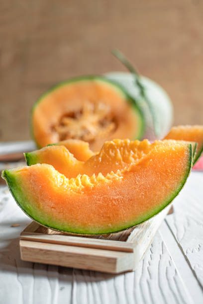 istock Orange melon on wooden cutting board and table 1155012733
