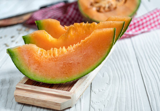 istock Orange melon on wooden cutting board and table 1155013168