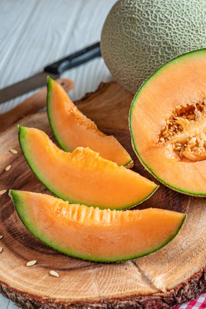 istock Orange melon on wooden cutting board and table 1155013225