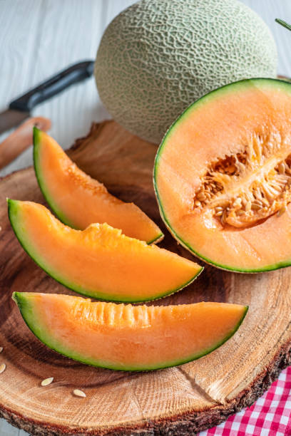 istock Orange melon on wooden cutting board and table 1155013231