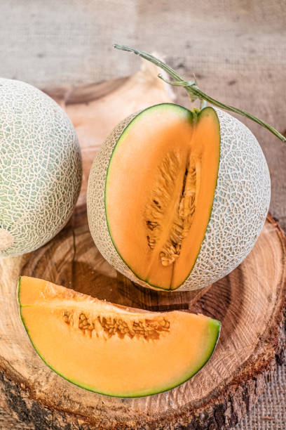 istock Orange melon on wooden cutting board and table 1155014329