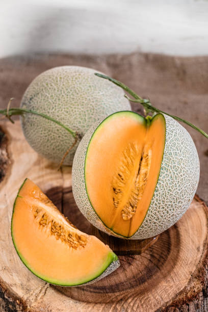 istock Orange melon on wooden cutting board and table 1155014340