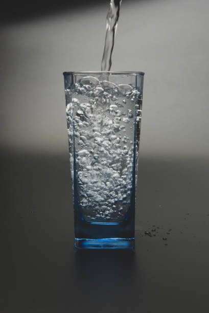 istock pouring fresh drink water to blue glass 1155014557