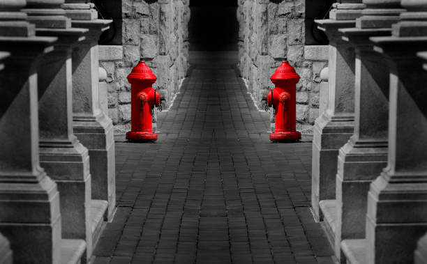 Red fire hydrants on sidewalk next to old stone buildings in long passageway