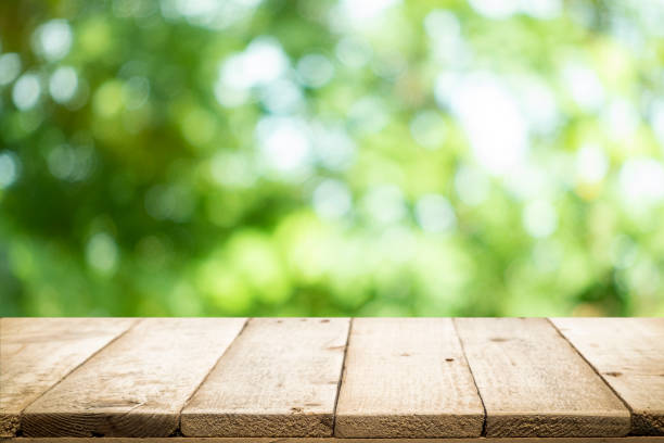 istock Empty table for present product with green bokeh out of focus background. 1155016327
