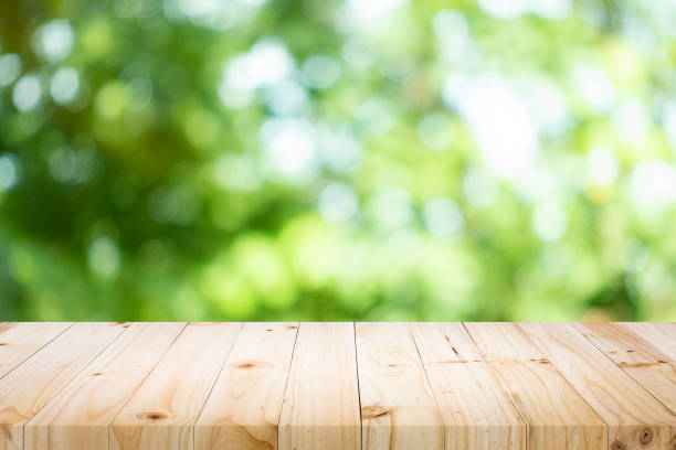 istock Empty table for present product with green bokeh out of focus background. 1155016330