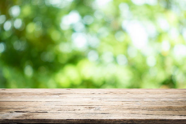 istock Empty table for present product with green bokeh out of focus background. 1155016332