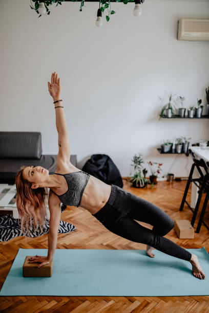 istock Young woman practicing yoga at home 1155017889