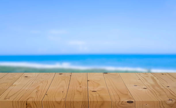 istock Empty wooden table with blurred sea background 1155019374