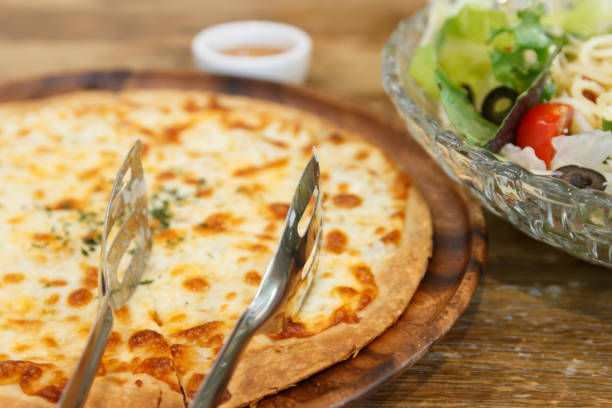 istock pizza and salad on the wooden table 1155020089