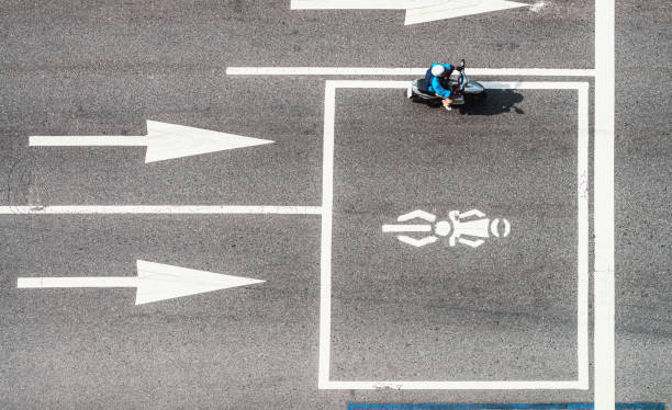 Motion blur as a scooter drives on a street in Taipei, Taiwan, with arrow road markings, and a box for moped drivers waiting for traffic lights.