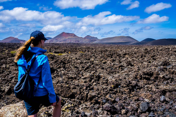 Spain, Lanzarote, Young woman enjoying stunning caldera lava and volcanoe landscape stock photo