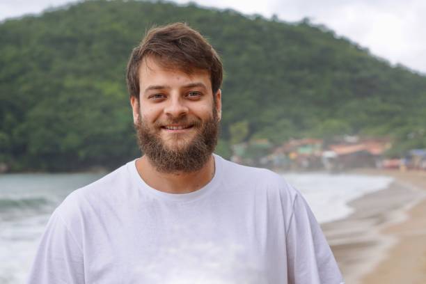 Close up portrait of a Brazilian man with blue eyes and a beard smiling stock photo