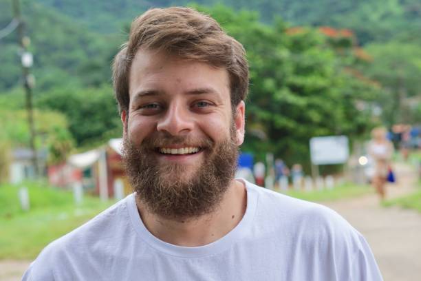 Close up portrait of a Brazilian man with blue eyes and a beard smiling stock photo