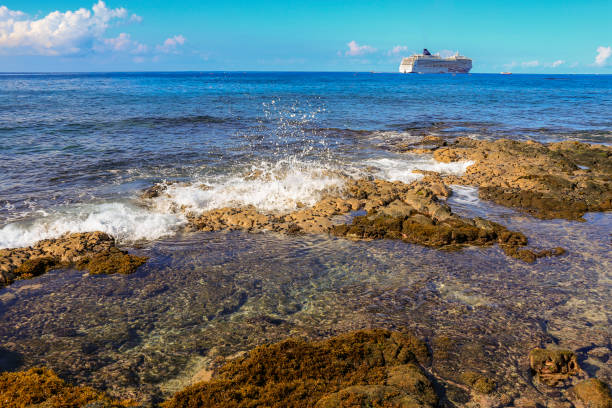istock wave breaking on reef with ship in distance 1155022875
