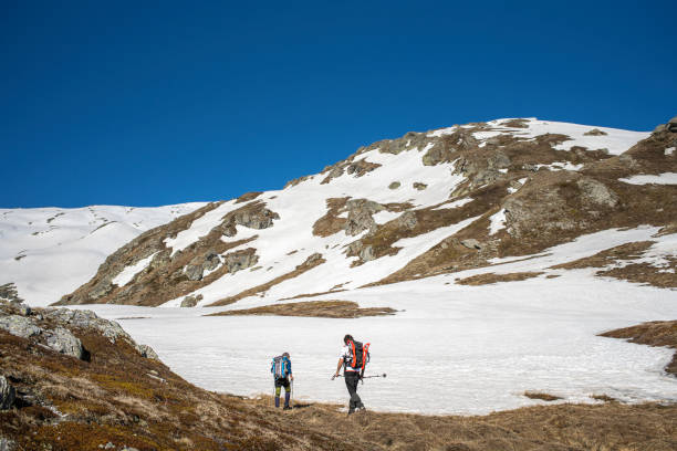 istock Two Hikers Walking on Snowy Mountain, Wilderness Area 1155022979