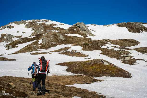 istock Two Hikers Walking on Snowy Mountain, Wilderness Area. 1155023454