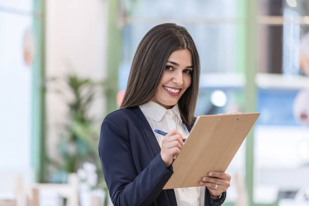 istock Woman writing in document on clipboard 1155024887