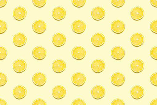 Lemon slices seamless pattern on pastel yellow background. Minimal summer concept. Flat lay, trendy juicy color.